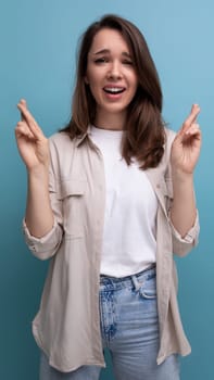 pretty young brunette female adult in casual shirt crossed her fingers.