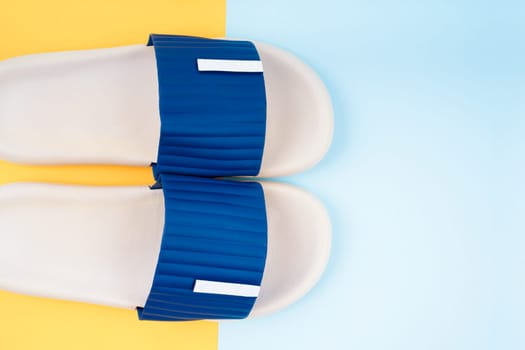 Top view of white and blue color rubber slipper shoes on beautiful background with copy space. Summer holiday vacation concept.