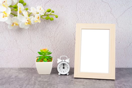 Blank picture frame and alarm clock on black floor with copy space and clipping path for the inside.