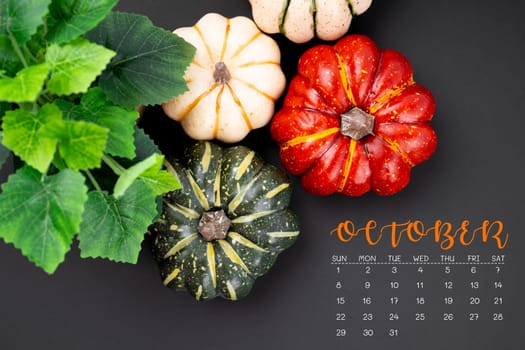 October 2023 Calendar and pumpkins on black color background.