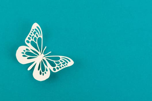 Paper butterfly carve on a green background with empty space.