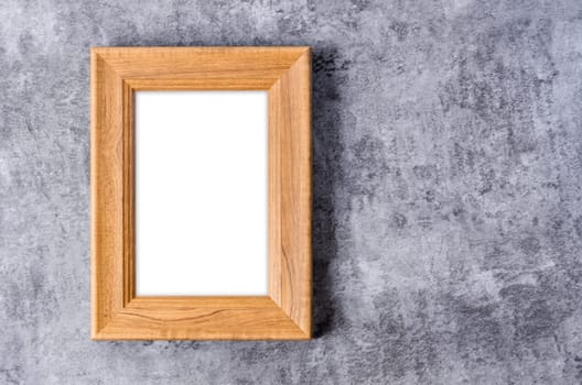 Empty vintage wooden photo frame isolated on dark wall, Save clipping path for the inside.