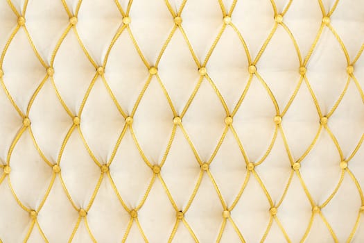 Classic upholstery in white and gold colors, texture.