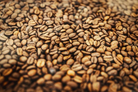 Background of brown roasted coffee beans, selective soft focus.