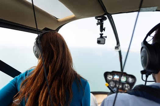 A woman passenger sitting in helicopter. Mid shot