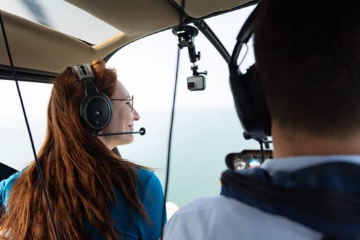 Smiling woman sitting in passenger seat in helicopter. Mid shot