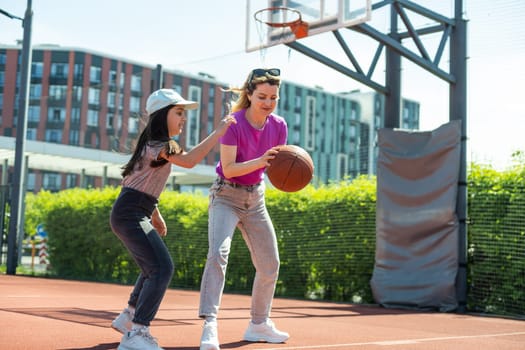 Mother and daughter playing basketball.