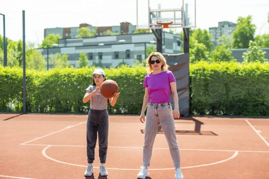 Mother and daughter playing basketball