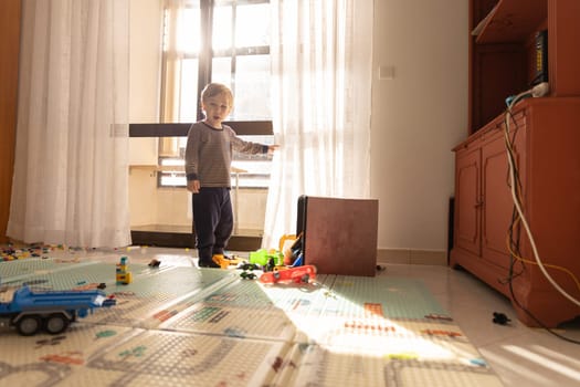 Cute blonde baby boy in the play room. Mid shot