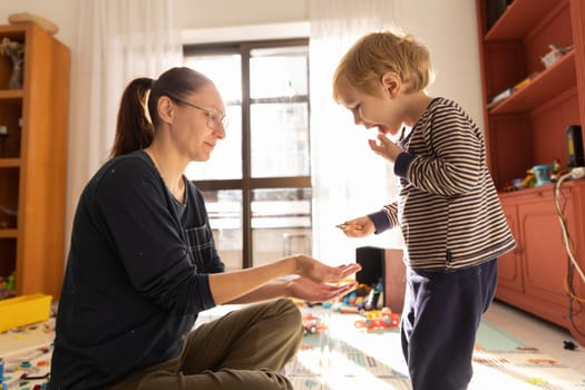 Mom and son eating cookies in the playroom. Mid shot