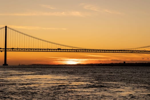 Suspension bridge over the sea at sunset. Mid shot
