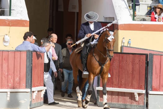 March 26, 2023 Lisbon, Portugal: Tourada - cavaleiro on horseback comes out of the paddock into the arena holding spear. Mid shot