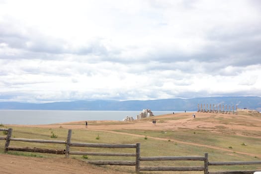 Thirteen pillars and the great shaman stone on Olkhon Island Lake Baikal awaits tourists and travelers in the foreground old fence