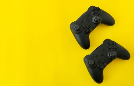 Isolated game joysticks on a yellow background. Gamer playing at home, relaxing with friends, competition