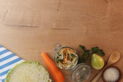 Cabbage lies on a wooden board with carrots, onions and herbs. Preparing to cook cabbage dishes.Copy space