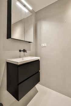 a modern bathroom with black cabinets and white countertops on the wall above the sink is an illuminated mirror
