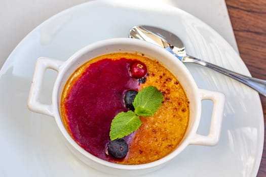 Dessert creme brulee or Catalan cream with mint leaves and berries.