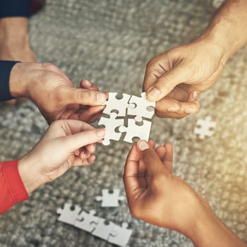 Hands, team and puzzle for teamwork or collaboration of business people for challenge or project. Above group of employees or friends building jigsaw together for solution, synergy or problem solving.