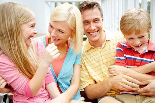 As close as family can be. a young family of four outside