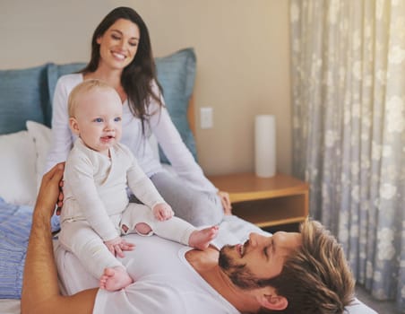 Happy mother, father and fun with baby in bedroom for love, care and quality time to relax together at home. Mom, dad and parents playing with infant kid for happiness, support or newborn development.