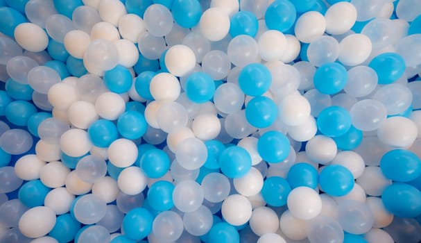 Blue and white plastic balls in ball pool at kids playground. Colorful plastic ball texture background. Many small colorful hollow plastic soft kids balls are in a ball pit. Play toy for kids.