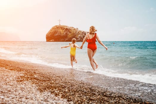 Happy loving family mother and daughter having fun together on the beach. Mum playing with her kid in holiday vacation next to the ocean - Family lifestyle and love concept.