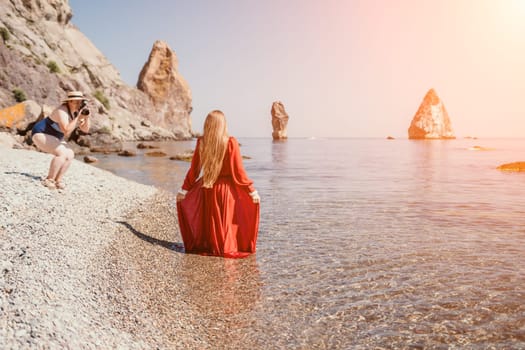 Woman travel sea. Happy tourist taking picture outdoors for memories. Woman traveler looks at the edge of the cliff on the sea bay of mountains, sharing travel adventure journey.