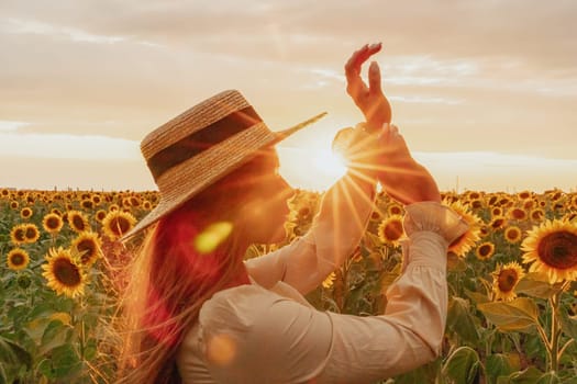 Woman in the sunflowers field. Summer time. Young beautiful woman standing in sunflower field.