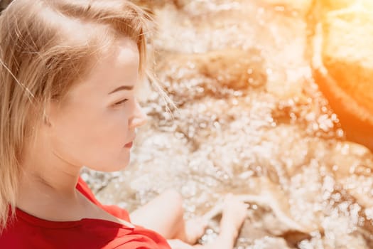 Woman travel sea. Young Happy woman in a long red dress posing on a beach near the sea on background of volcanic rocks, like in Iceland, sharing travel adventure journey