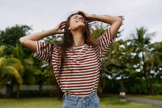 walk woman wellness hat nature park lifestyle girl long beautiful exercise happy smiling beauty care t-shirt hair health day striped summer run freedom