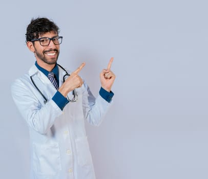 Bearded doctor pointing a promotion with finger isolated. Happy bearded doctor pointing at advertising space isolated