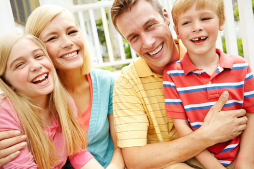 As close as family can be. a young family of four outside