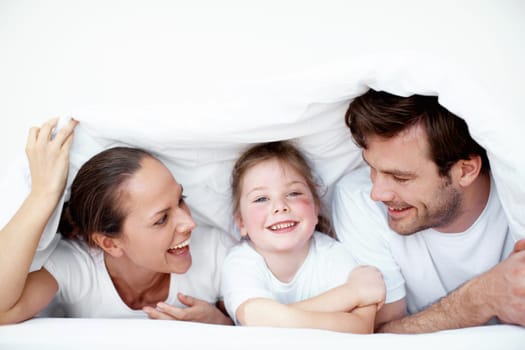 A family fort. A young family plying under neath the bedsheets