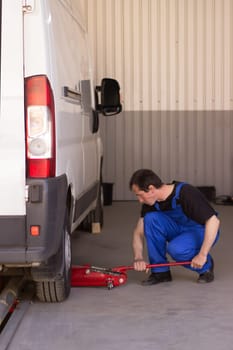 Mechanic uses jackscrew in the auto service