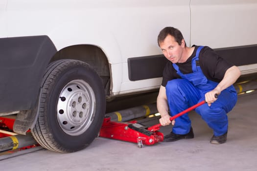 Mechanic uses jackscrew in the auto service