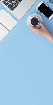 Business concept. Clean bright light blue office table desk, minimal style with laptop coffee and smart phone, copy space, top view, flat lay, mockup