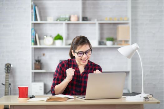 Beautiful asian woman relaxing using laptop computer while sitting on table. Creative girl working and typing on keyboard at home.work at home concept