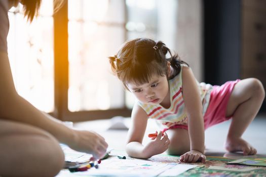 cute baby girl painting with her mother at the house