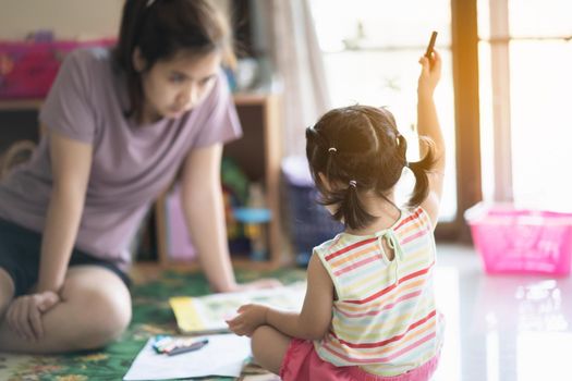 cute baby girl painting with her mother at the house