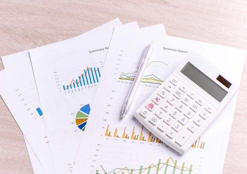 White calculator and report with chart and graph, concept of annual financial profit overview, banking and investment, close up, copy space, macro