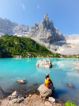 woman on vacation in the Italian Dolomites, Lago di Sorapis, Lake Sorapis, Dolomites, Italy. woman by the lake