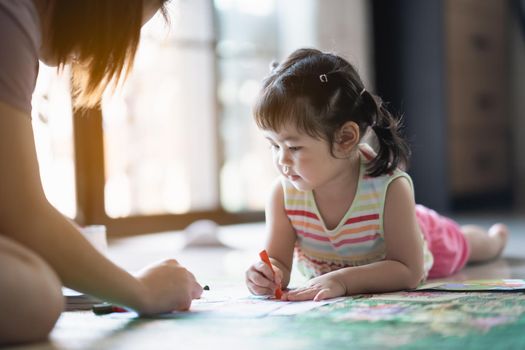 cute baby girl painting with her mother at the house