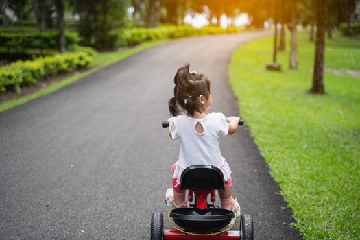 cute baby riding bicycle in the garden