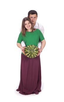 A man and a pregnant woman are holding a large watermelon in their hands. isolated on white background.