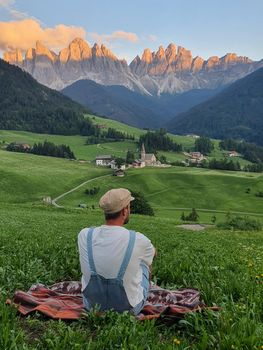  Italian Dolomites, Santa Maddalena Santa Magdalena village with magical Dolomites mountains in autumn, Val di Funes valley, Trentino Alto Adige region, South Tyrol, Italy, Europe. Santa Maddalena Village, Italy. man looking at mountain