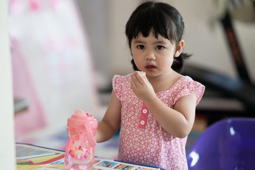 cute baby girl eating cookies in the house