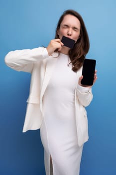 card payment. brunette young woman in dress and jacket holding card mockup and smartphone.