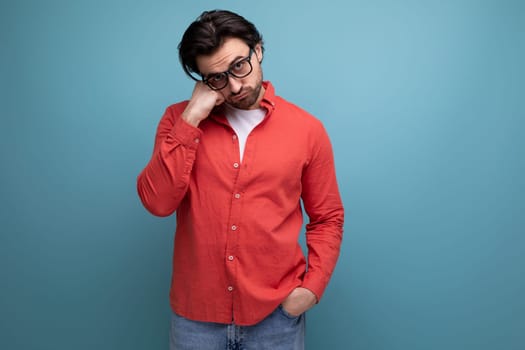 upset 35 year old brunette millennial man with gorgeous hair in a red shirt.