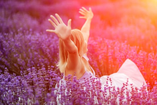 Woman lavender field. A middle-aged woman sits in a lavender field and enjoys aromatherapy. Aromatherapy concept, lavender oil, photo session in lavender.