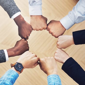 Team building, fist bump or hands of business people for diversity, group support or community in office. Teamwork, above or circle of fists for motivation, collaboration or partnership for a mission.